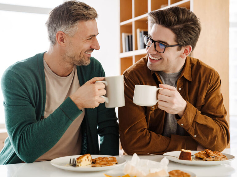 Happy couple drinking coffee while having breakfast