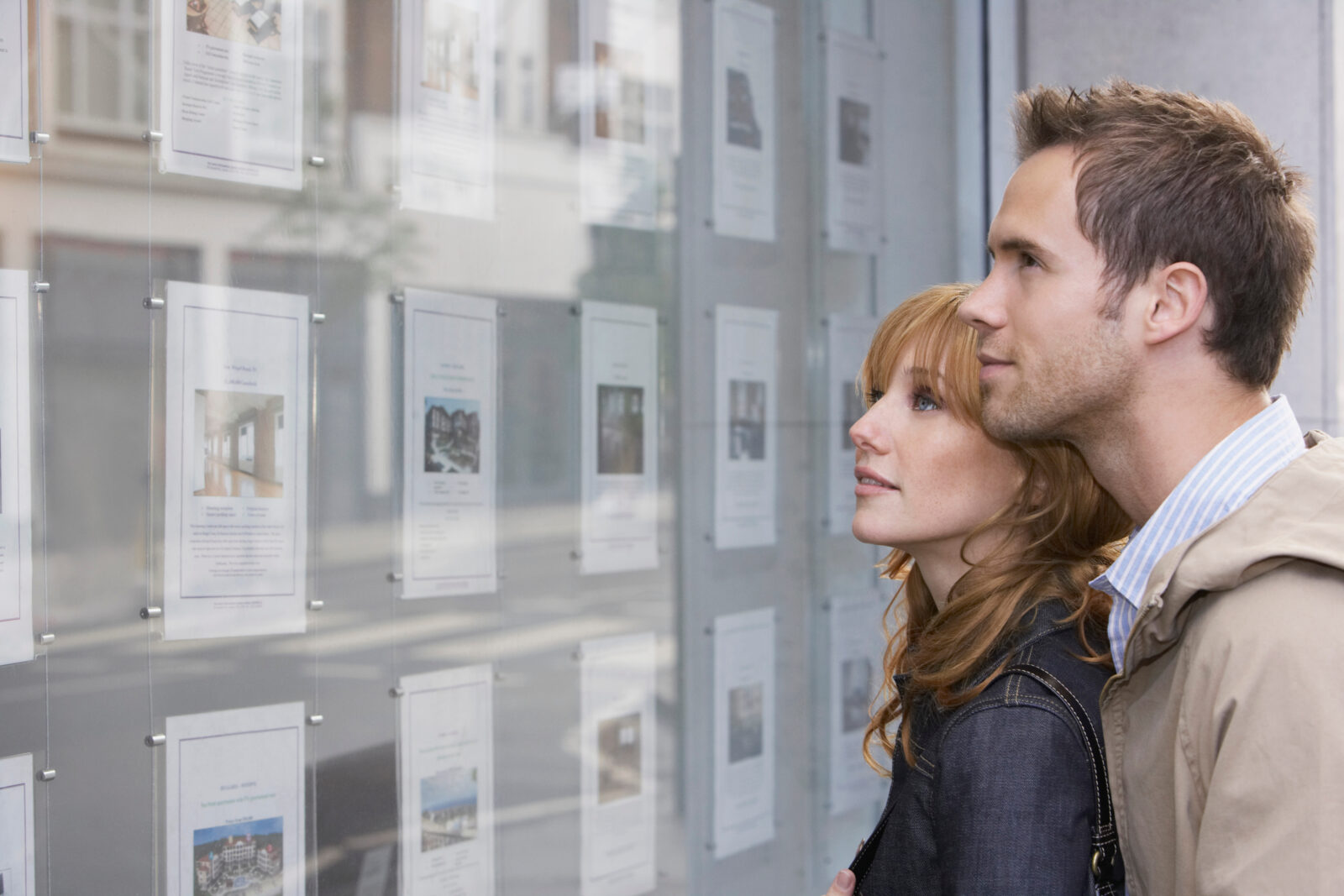 Couple Looking At Display At Real Estate Office