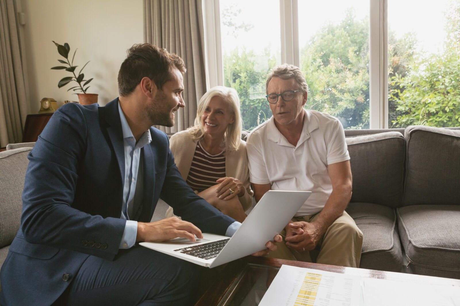 Active senior couple discussing with real estate agent over lapt